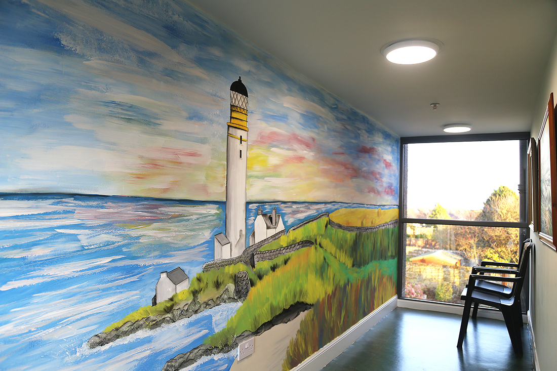 Large painting of a lighthouse on hallway wall.